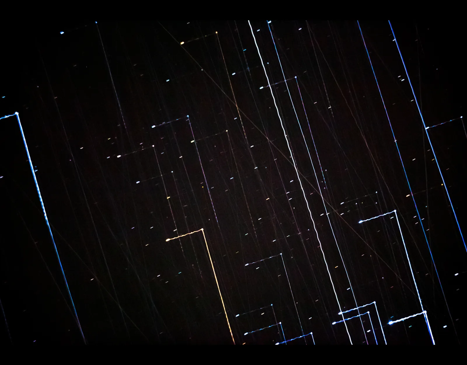 Lichtspuren und Sternspuren auf Schwarz, Langzeitbelichtung
