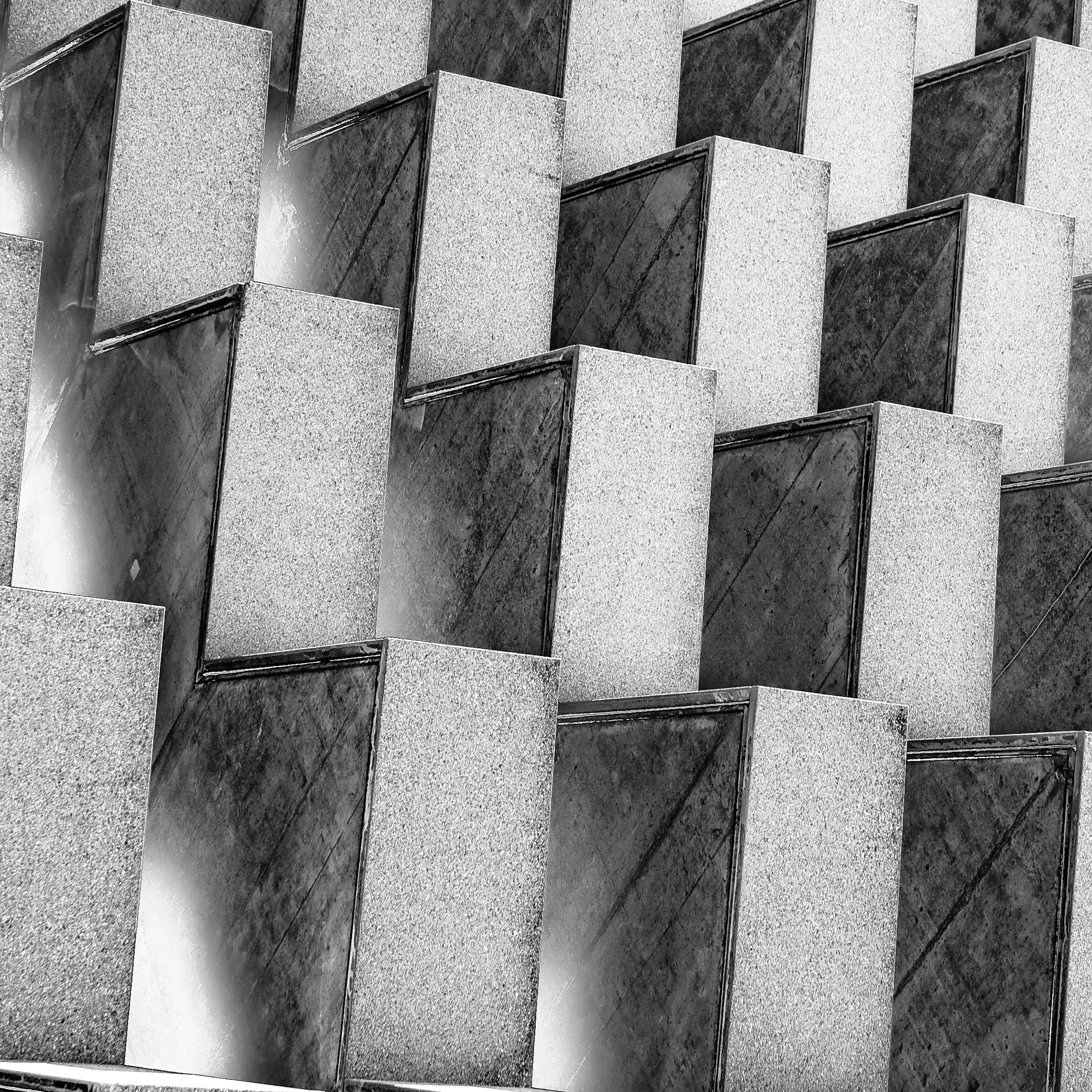 Schwarzweiß: gestaffelte Betonelemente einer Fassade