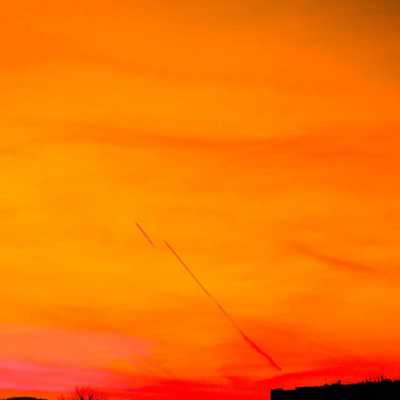 Orange leuchtender Abendhimmel mit Kondensstreifen