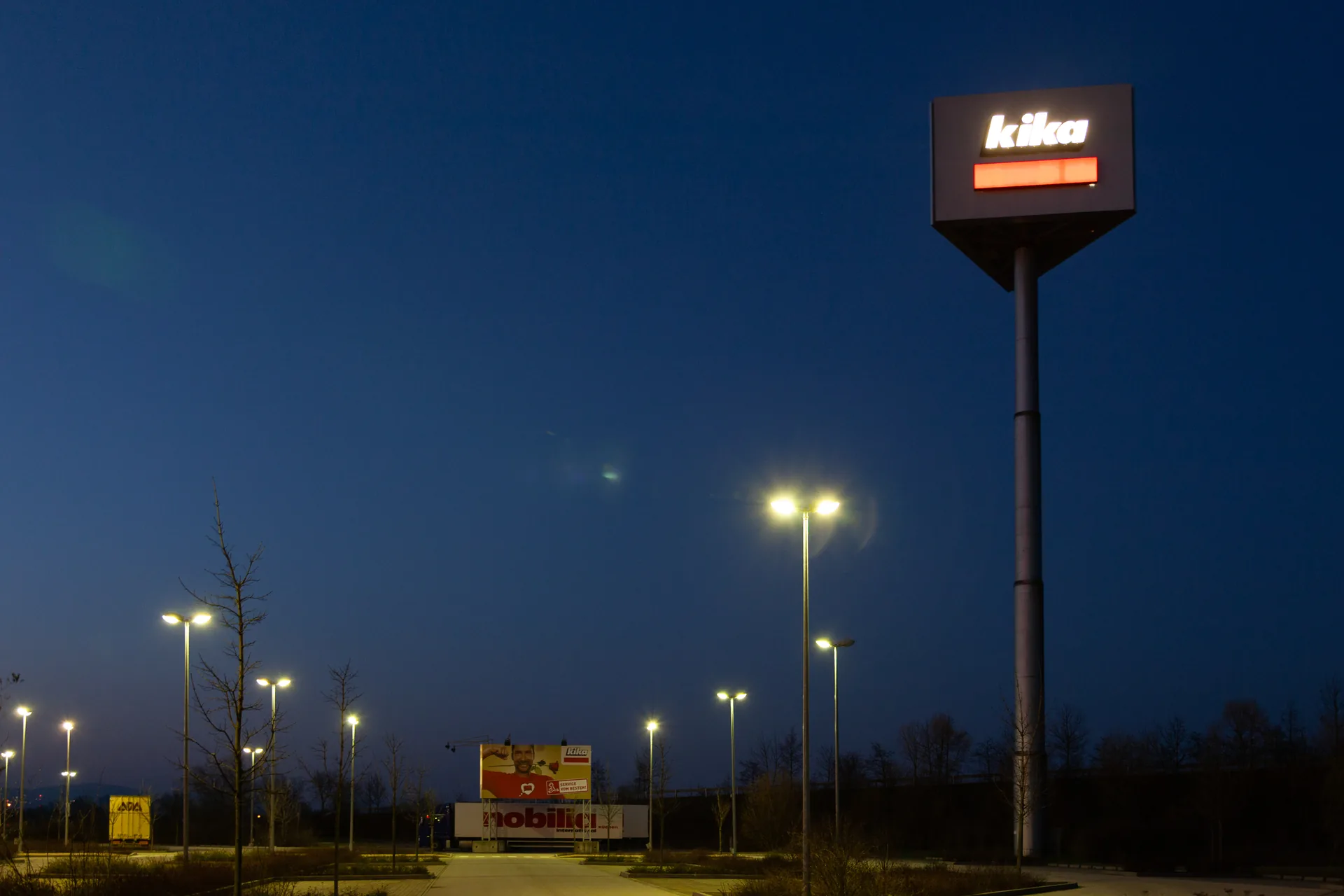Tankstellenschild und Laternen bei Nacht