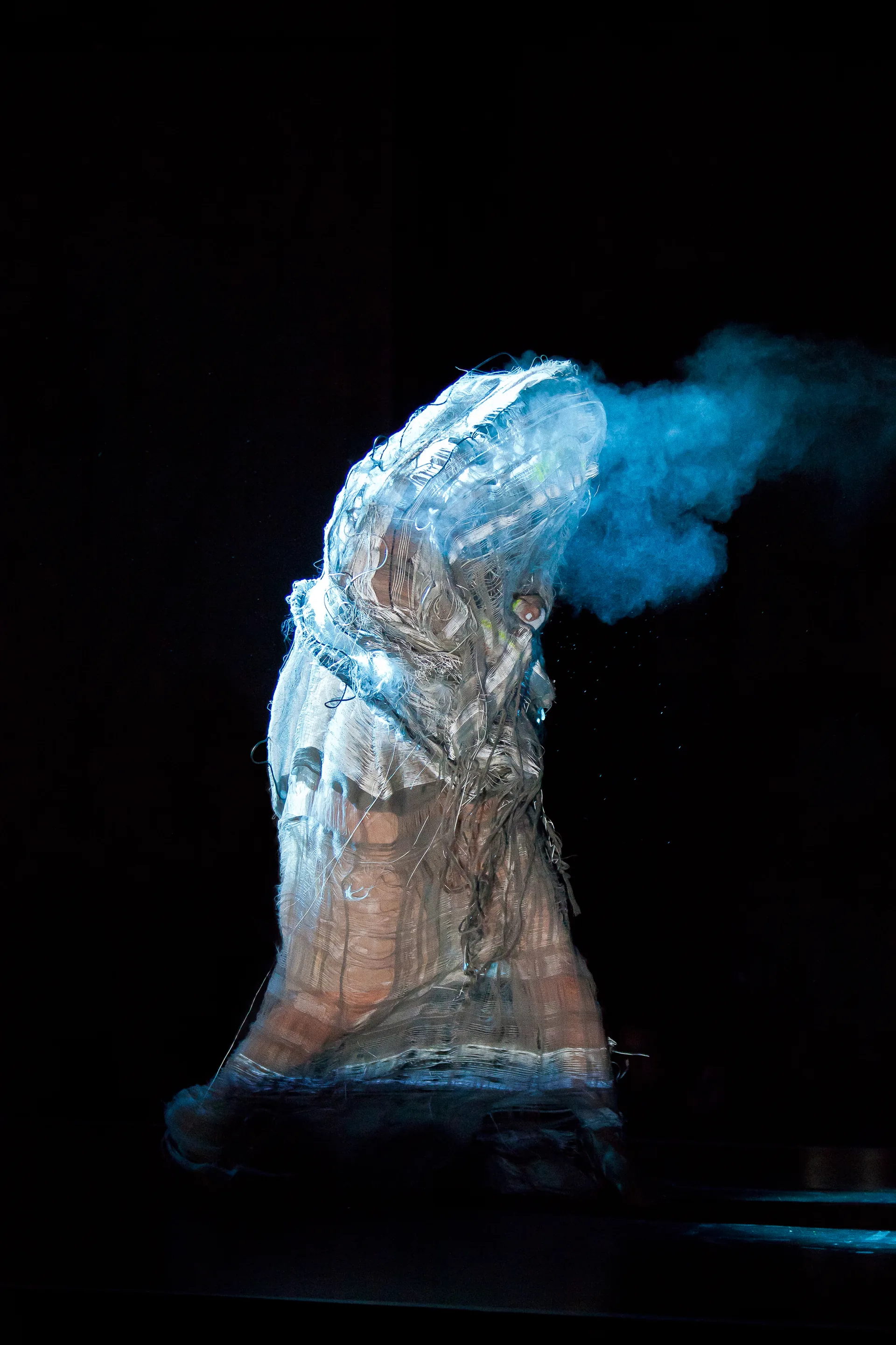 Skulptur mit blauem Rauch vor Schwarz